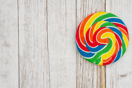 Colorful swirl lollipop on weathered wood for your party messageの写真素材