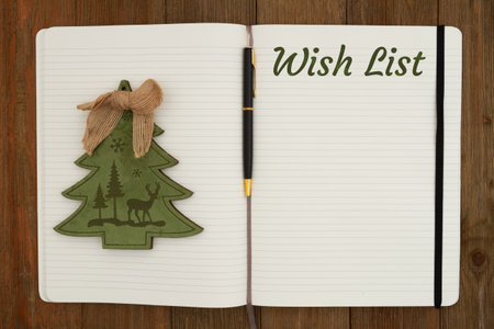 Wish List with a pen and Christmas tree on ruled line journal paper page notepad on weathered deskの写真素材