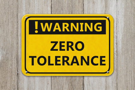 Warning Zero Tolerance yellow sign on a weathered wood wallの写真素材
