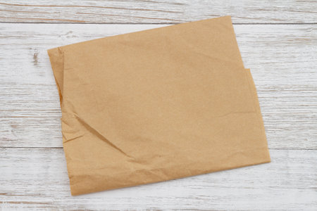 Brown crumpled butcher paper on weathered wood with textureの写真素材