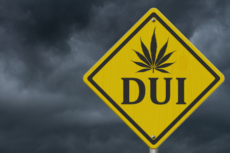 Yellow warning DWI marijuana leaf road sign with stormy sky