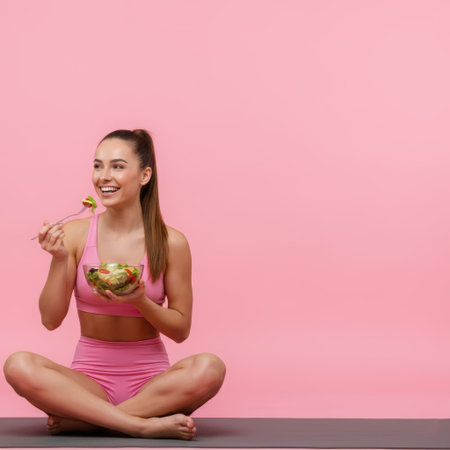 Fitness, girl eating salad on exercise mat, healthy food, proper nutrition, healthy lunch, health care, exercise, yoga. High qualityの素材