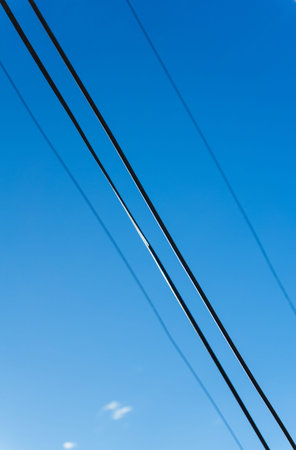Electricity wires against a blue sky, black wires, modern technology. High quality