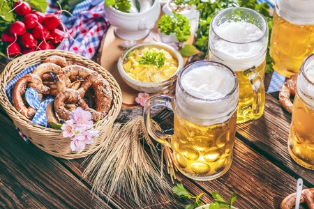 Oktoberfest beer, pretzels and various Bavarian specialties on wooden backgroundの写真素材