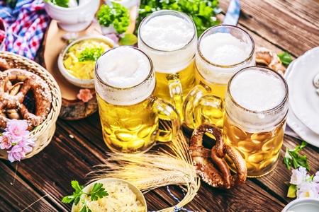 Oktoberfest beer, pretzels and various Bavarian specialties on wooden backgroundの写真素材