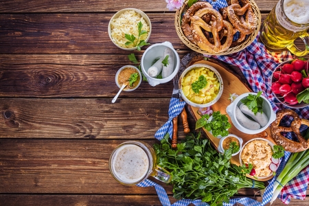 Oktoberfest beer, pretzels and various Bavarian specialties on wooden backgroundの写真素材