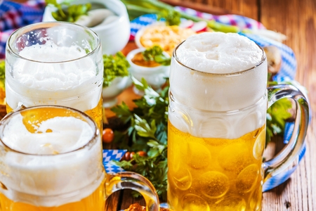 Oktoberfest beer, pretzels and various Bavarian specialties on wooden backgroundの写真素材