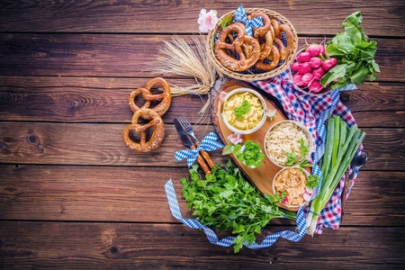 Oktoberfest beer, pretzels and various Bavarian specialties on wooden backgroundの写真素材