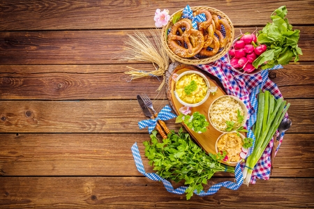 Oktoberfest beer, pretzels and various Bavarian specialties on wooden backgroundの写真素材