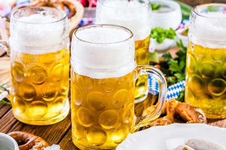 Oktoberfest beer, pretzels and various Bavarian specialties on wooden backgroundの写真素材