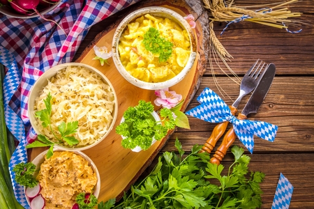 Oktoberfest beer, pretzels and various Bavarian specialties on wooden backgroundの写真素材