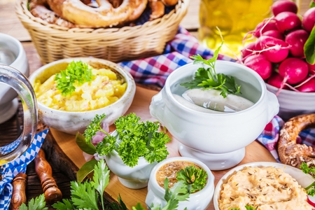 Oktoberfest beer, pretzels and various Bavarian specialties on wooden backgroundの写真素材