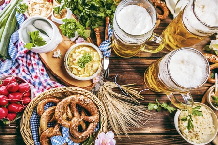 Oktoberfest beer, pretzels and various Bavarian specialties on wooden backgroundの写真素材