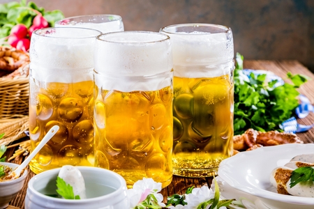 Oktoberfest beer, pretzels and various Bavarian specialties on wooden backgroundの写真素材