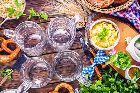 Oktoberfest beer, pretzels and various Bavarian specialties on wooden backgroundの写真素材