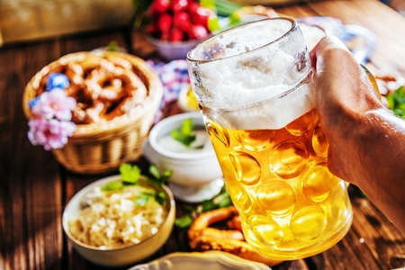 Oktoberfest beer, pretzels and various Bavarian specialties on wooden backgroundの写真素材