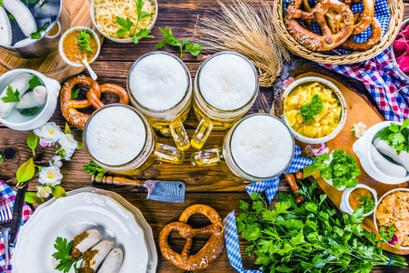 Oktoberfest beer, pretzels and various Bavarian specialties on wooden backgroundの写真素材