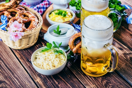 Oktoberfest beer, pretzels and various Bavarian specialties on wooden backgroundの写真素材