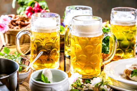 Oktoberfest beer, pretzels and various Bavarian specialties on wooden backgroundの写真素材