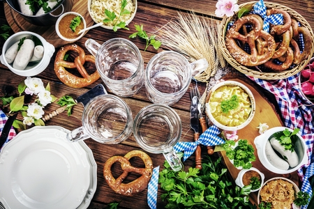 Oktoberfest beer, pretzels and various Bavarian specialties on wooden backgroundの写真素材