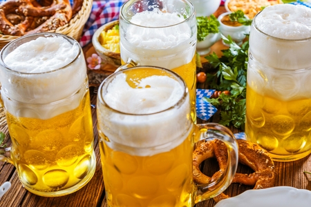 Oktoberfest beer, pretzels and various Bavarian specialties on wooden backgroundの写真素材