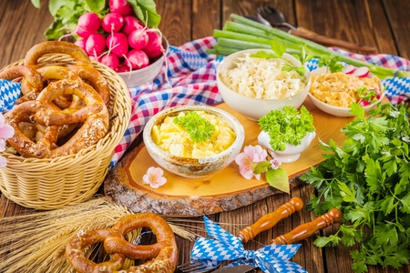 Oktoberfest beer, pretzels and various Bavarian specialties on wooden backgroundの写真素材
