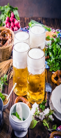 Oktoberfest beer, pretzels and various Bavarian specialties on wooden backgroundの写真素材