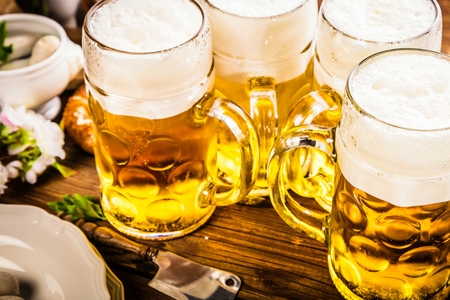 Oktoberfest beer, pretzels and various Bavarian specialties on wooden backgroundの写真素材