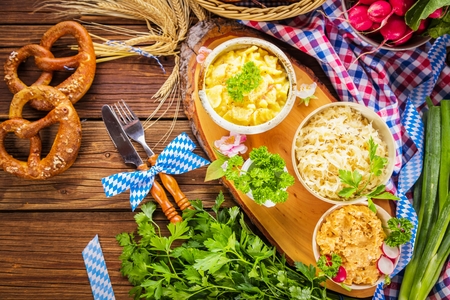 Oktoberfest beer, pretzels and various Bavarian specialties on wooden backgroundの写真素材