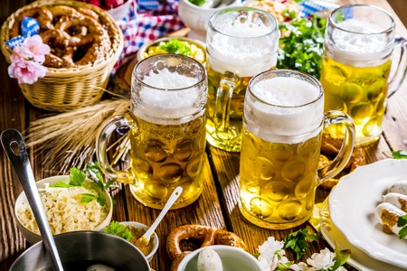 Oktoberfest beer, pretzels and various Bavarian specialties on wooden backgroundの写真素材