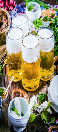 Oktoberfest beer, pretzels and various Bavarian specialties on wooden backgroundの写真素材