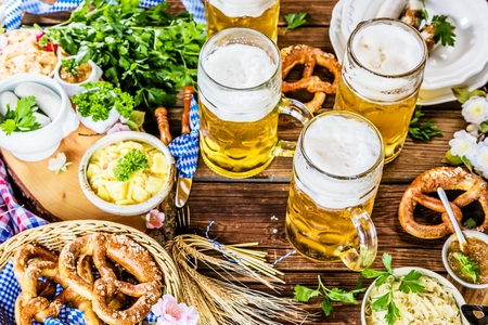 Oktoberfest beer, pretzels and various Bavarian specialties on wooden backgroundの写真素材