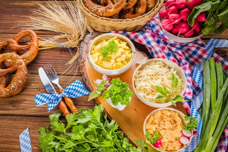 Oktoberfest beer, pretzels and various Bavarian specialties on wooden backgroundの写真素材