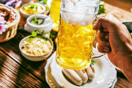 Oktoberfest beer, pretzels and various Bavarian specialties on wooden backgroundの写真素材