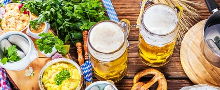 Oktoberfest beer, pretzels and various Bavarian specialties on wooden backgroundの写真素材