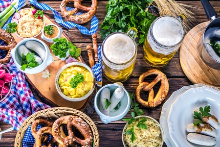Oktoberfest beer, pretzels and various Bavarian specialties on wooden backgroundの写真素材