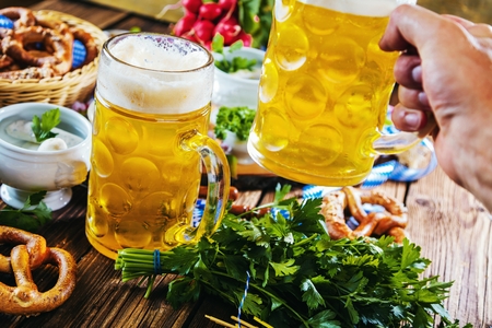 Oktoberfest beer, pretzels and various Bavarian specialties on wooden backgroundの写真素材