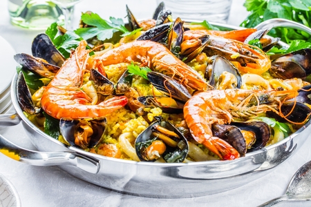 Traditional seafood paella in the pan on a wooden tableの写真素材