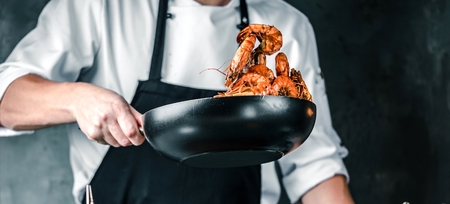 Chef cooking with Tiger prawn on dark backgroundの写真素材