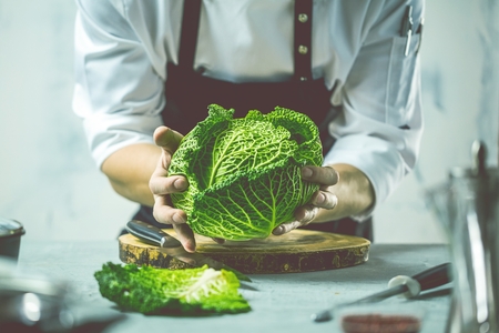 Chef cook preparing vegetables in his kitchen.の写真素材
