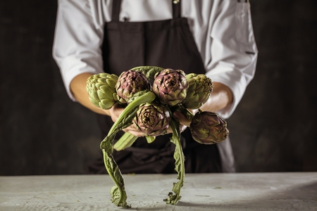 Chef cook preparing vegetables in his kitchen.の写真素材