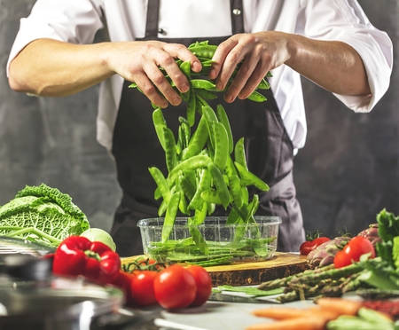 Chef cook preparing vegetables in his kitchen.の写真素材