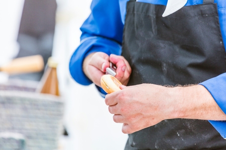 Chef cutting fresh bread for Burger