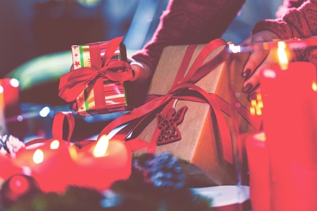 Woman Wrapping and Decorating Christmas Present