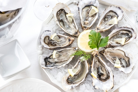 beautiful appetizer oysters two glasses wine champagne.の写真素材