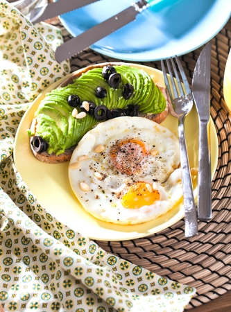 Fried egg. Close up view of the fried egg on a frying pan. Salted and spiced fried egg with parsley on cast iron pan and black backgroundの写真素材