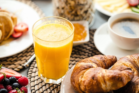 Breakfast served with coffee, orange juice and croissantsの写真素材