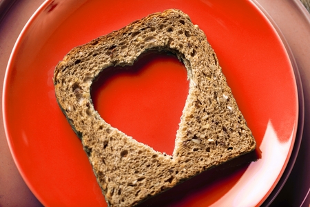 Slice of cereal toast bread with cut out heart shapeの写真素材