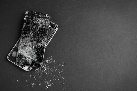 mobile phone with broken touchscreen on gray background.の写真素材
