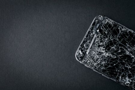 mobile phone with broken touchscreen on gray background.の写真素材